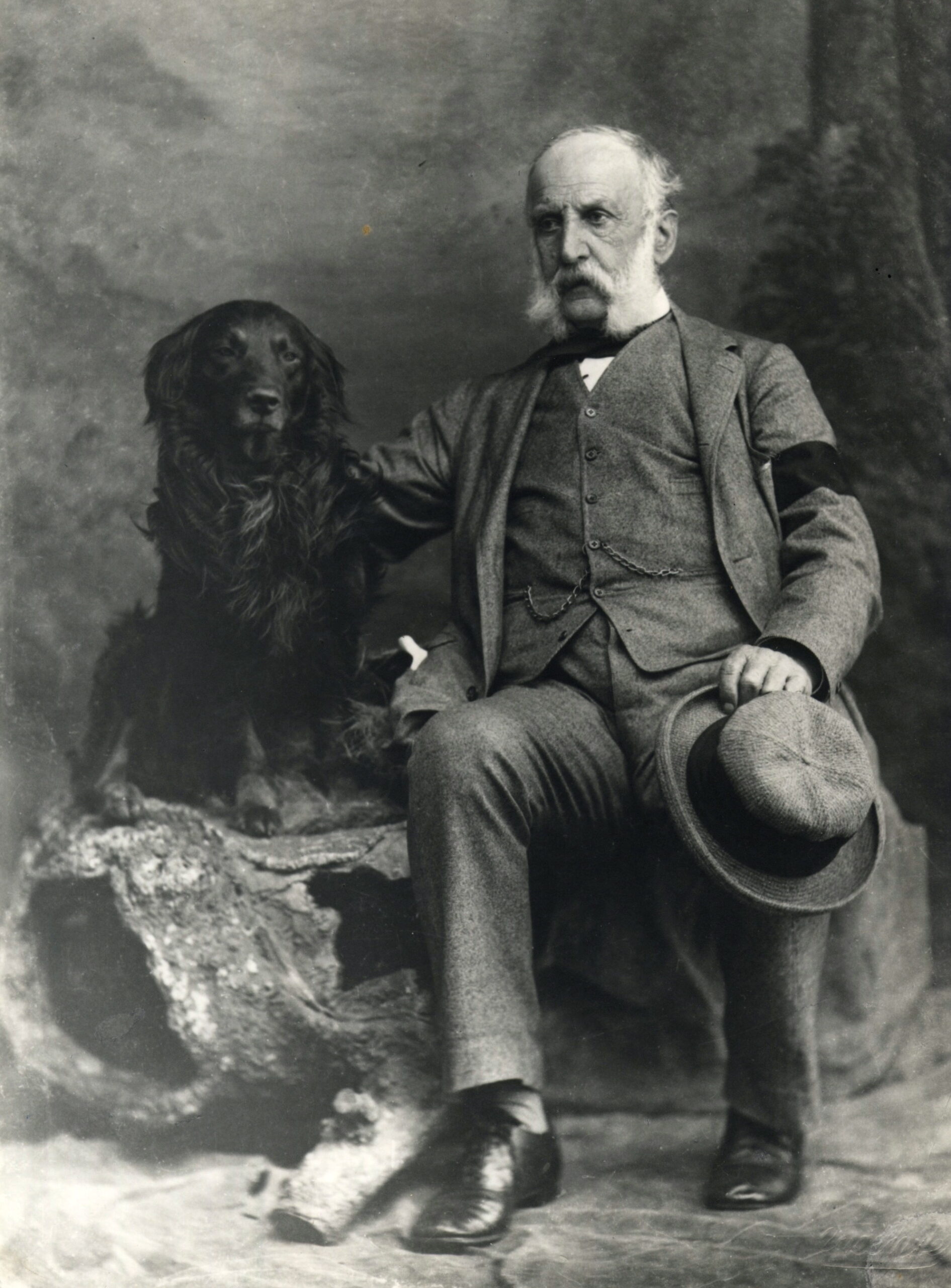 Portrait of William Hinton seated beside a dog.